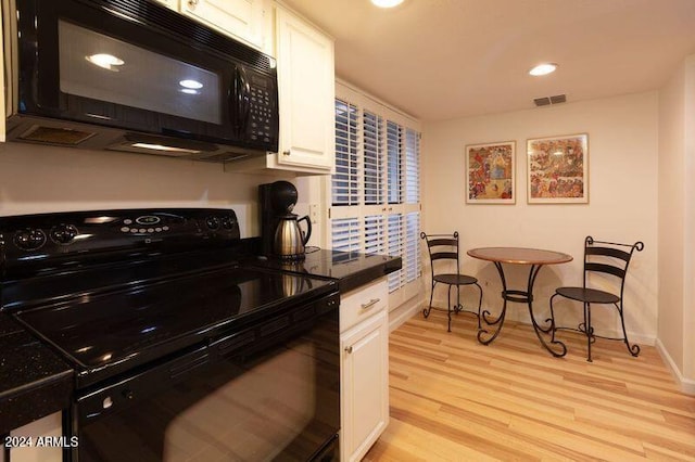 kitchen featuring black appliances, white cabinetry, and light hardwood / wood-style flooring