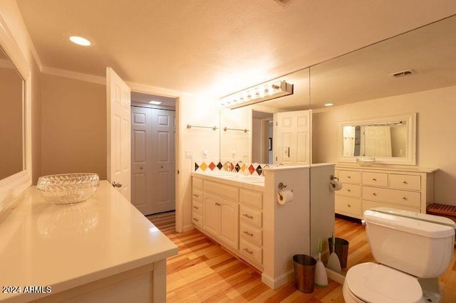 bathroom featuring vanity, toilet, and hardwood / wood-style flooring