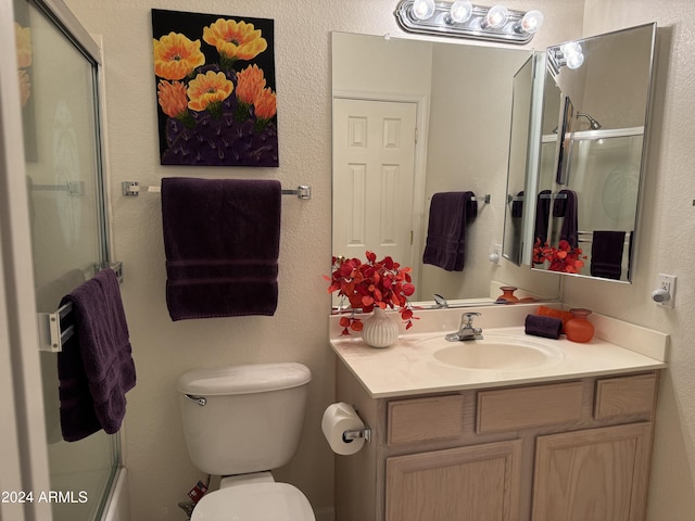 full bath with vanity, toilet, and a textured wall