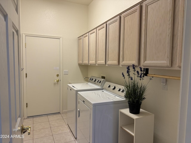 washroom with light tile patterned flooring, cabinet space, and washer and dryer