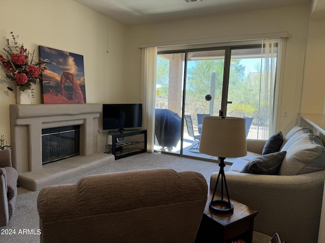 carpeted living area with visible vents and a glass covered fireplace