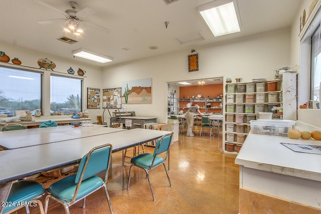 dining space with visible vents, a healthy amount of sunlight, ceiling fan, and attic access