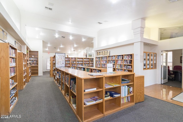 misc room with visible vents, carpet floors, and bookshelves