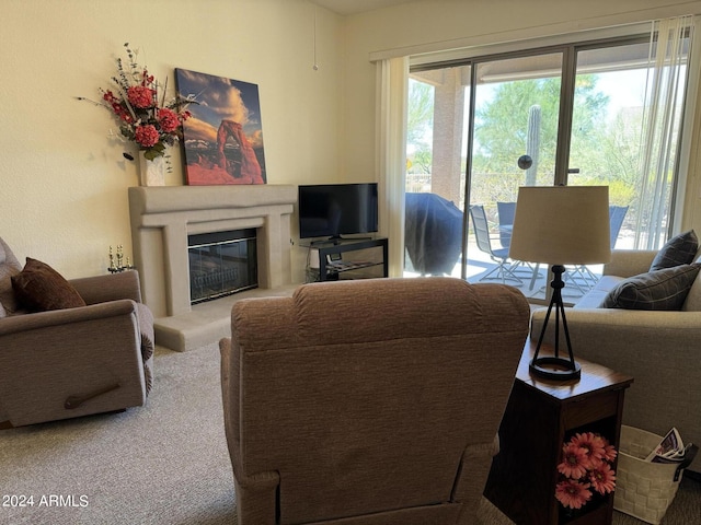 carpeted living area featuring a glass covered fireplace