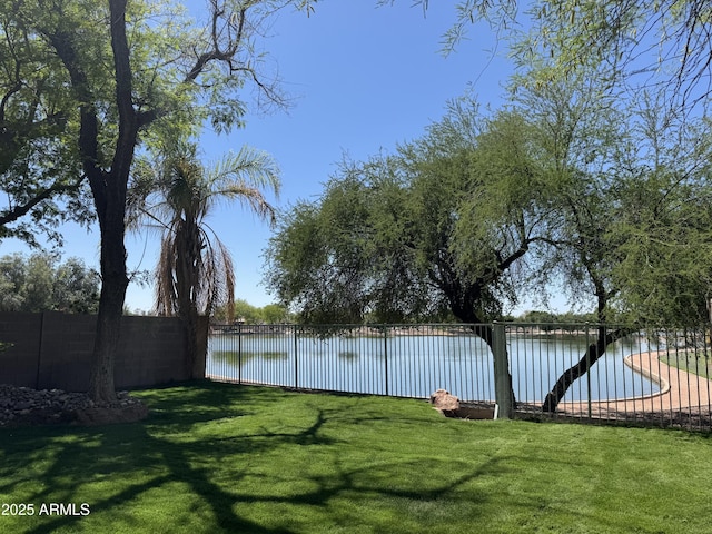 view of yard featuring fence and a water view