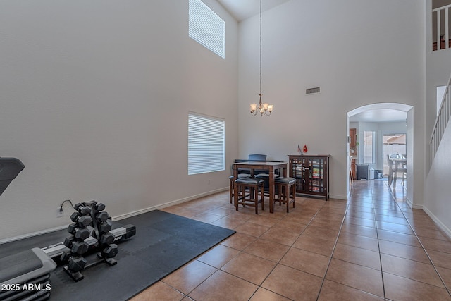 dining room with a high ceiling, arched walkways, a healthy amount of sunlight, and visible vents