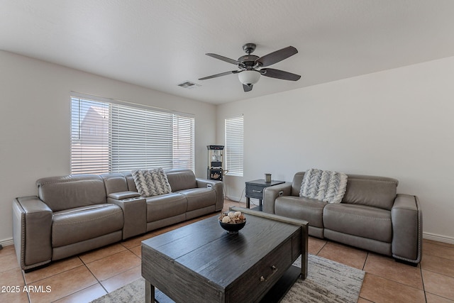 living room featuring ceiling fan, baseboards, light tile patterned floors, and visible vents