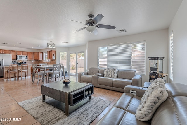 living room with light tile patterned floors, ceiling fan, recessed lighting, and visible vents