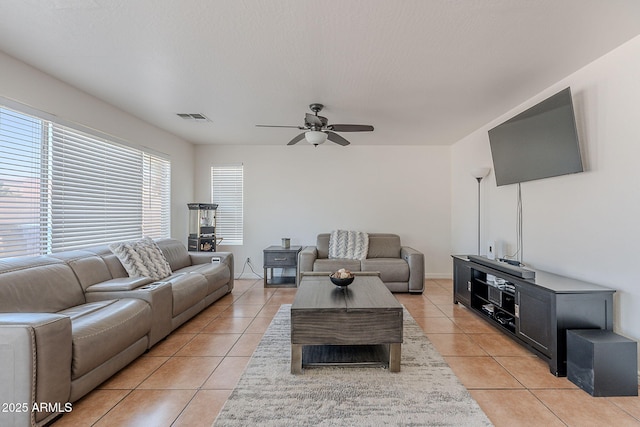 living room with ceiling fan, visible vents, and light tile patterned flooring