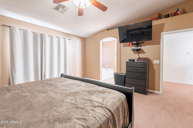 bedroom with lofted ceiling, carpet, visible vents, arched walkways, and baseboards