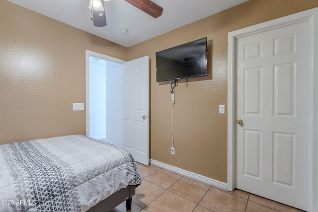bedroom featuring light tile patterned floors, baseboards, and ceiling fan