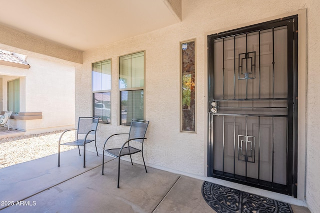 doorway to property featuring a porch and stucco siding