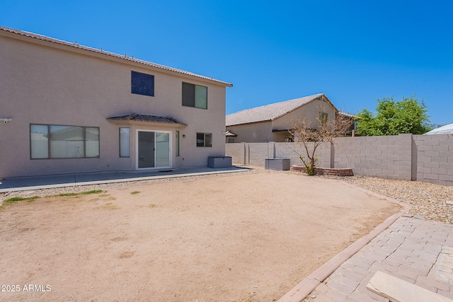 rear view of property featuring a patio area, stucco siding, and a fenced backyard