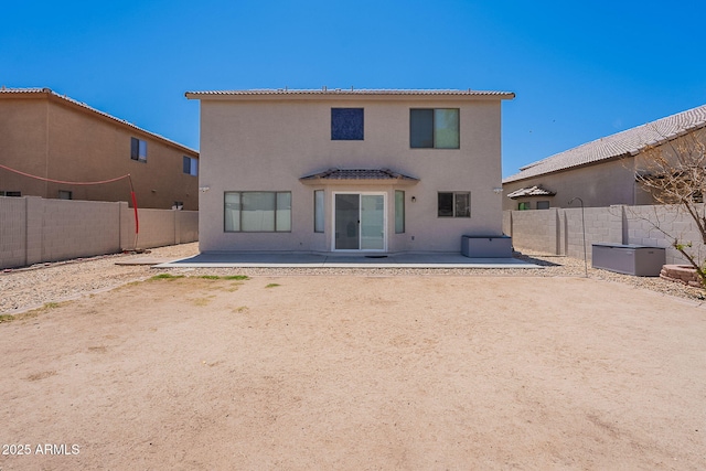 rear view of property with a patio area, stucco siding, and a fenced backyard
