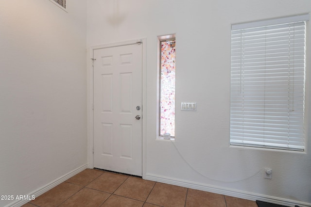 entrance foyer featuring light tile patterned floors, visible vents, and baseboards