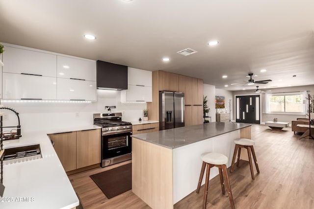 kitchen with white cabinetry, stainless steel appliances, a center island, and a breakfast bar area