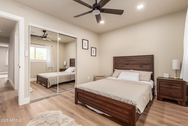 bedroom with light hardwood / wood-style flooring, a closet, and ceiling fan