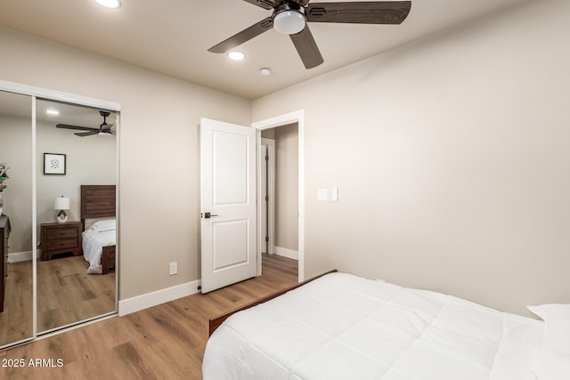 bedroom with ceiling fan, wood-type flooring, and a closet