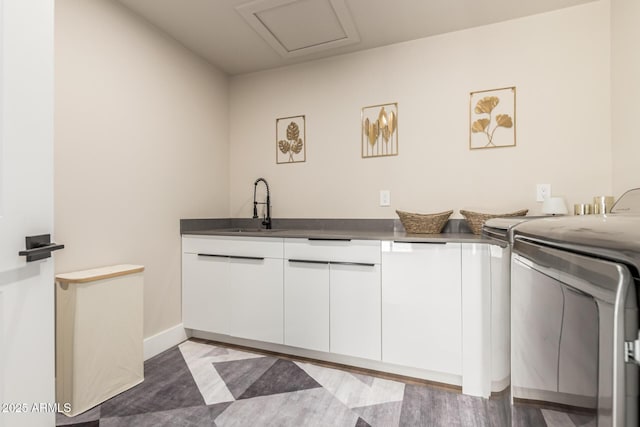 washroom featuring washer and dryer, sink, and cabinets