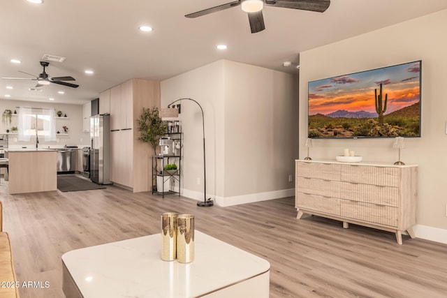 living room with ceiling fan and light wood-type flooring