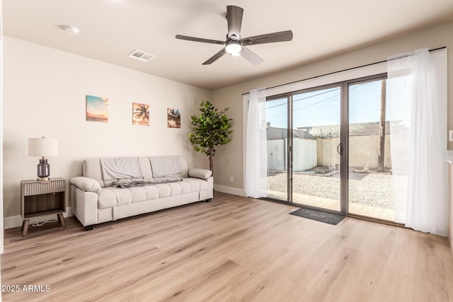 living room with light hardwood / wood-style flooring and ceiling fan