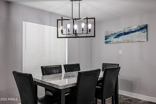 dining area with baseboards and a notable chandelier