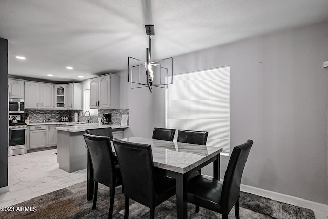 dining space featuring baseboards, an inviting chandelier, recessed lighting, a textured ceiling, and marble finish floor