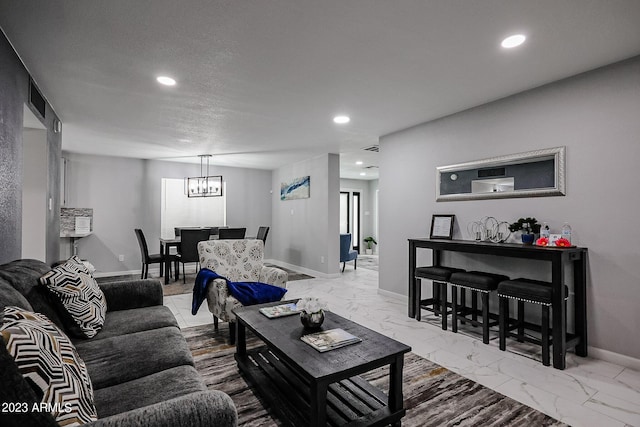 living room with marble finish floor, a textured ceiling, recessed lighting, an inviting chandelier, and baseboards