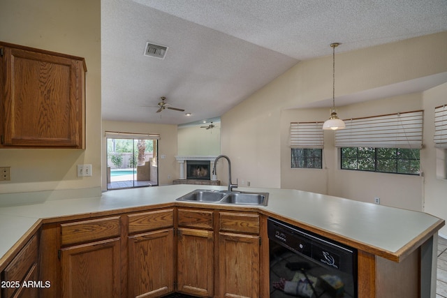 6101 E Beck Ln, Scottsdale, AZ 85254 - kitchen featuring dishwasher, a fireplace with raised hearth, a ceiling fan, light countertops, and a textured ceiling