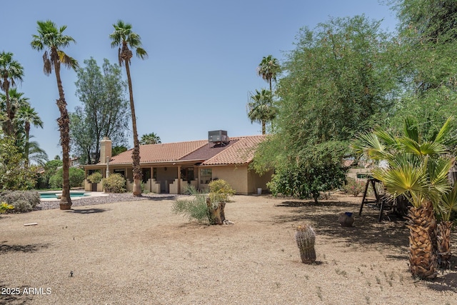 6101 E Beck Ln, Scottsdale, AZ 85254 - view of front of home with a tile roof, an outdoor pool, a chimney, and stucco siding