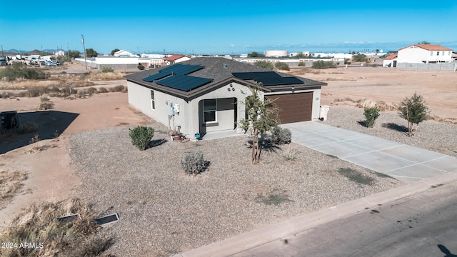 view of front of property featuring solar panels and a garage