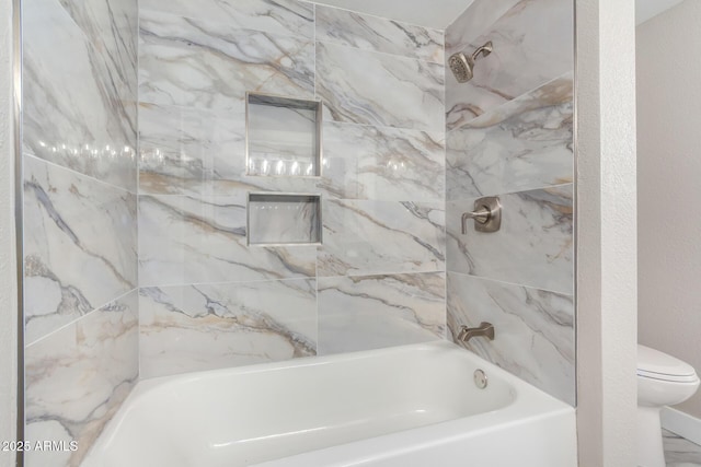 bathroom with toilet and tiled shower / bath