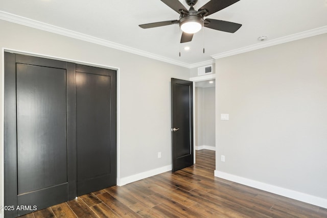 unfurnished bedroom with ceiling fan, ornamental molding, a closet, and dark hardwood / wood-style floors