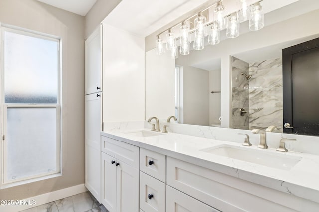 bathroom with a tile shower, vanity, and toilet