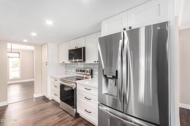 kitchen featuring appliances with stainless steel finishes, a textured ceiling, dark hardwood / wood-style floors, white cabinets, and backsplash