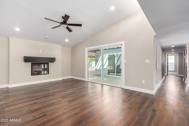 unfurnished living room featuring dark hardwood / wood-style flooring, a multi sided fireplace, and a wealth of natural light