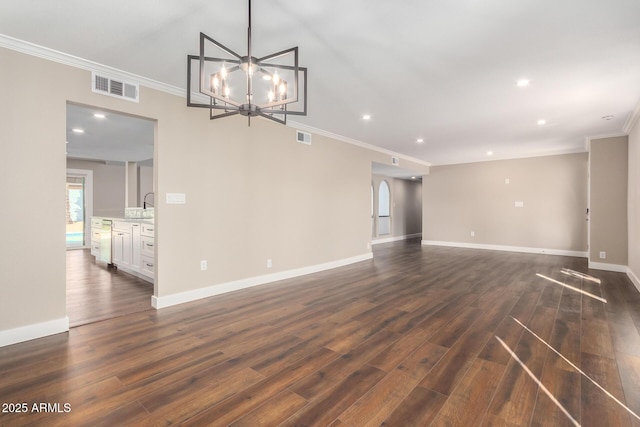 unfurnished living room with sink, dark wood-type flooring, crown molding, and a chandelier