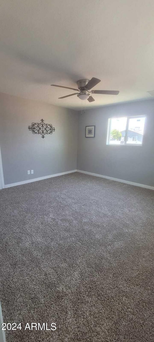 carpeted empty room with baseboards and ceiling fan