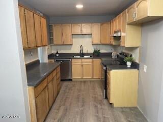 kitchen with light wood-style flooring, electric stove, a sink, dark countertops, and dishwasher