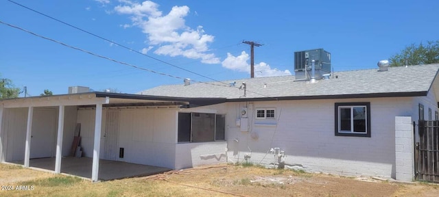 back of house featuring cooling unit, a shingled roof, a patio, and fence