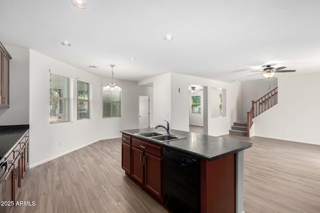 kitchen featuring dark countertops, a sink, light wood finished floors, ceiling fan with notable chandelier, and dishwasher