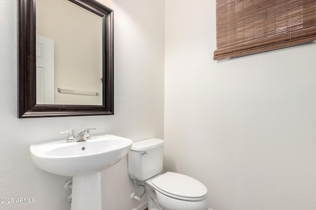 half bathroom featuring toilet