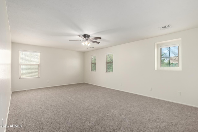 carpeted empty room featuring a ceiling fan, baseboards, and visible vents