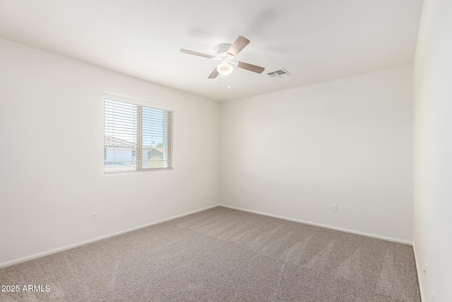 unfurnished room with ceiling fan, visible vents, baseboards, and carpet