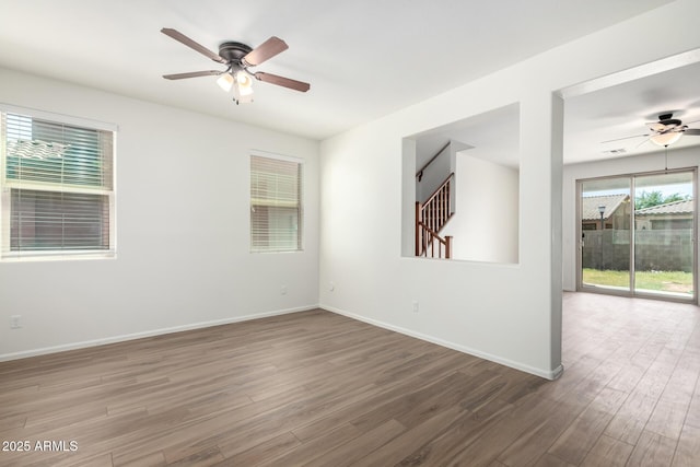 empty room featuring baseboards, ceiling fan, and wood finished floors