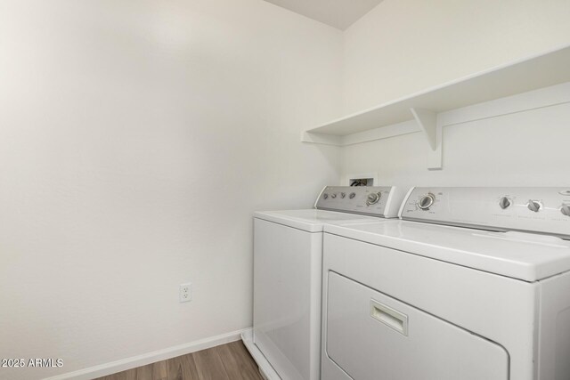 clothes washing area with laundry area, light wood finished floors, baseboards, and separate washer and dryer