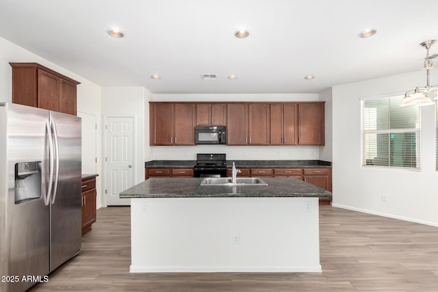 kitchen with a center island with sink, recessed lighting, a sink, light wood-style flooring, and black appliances