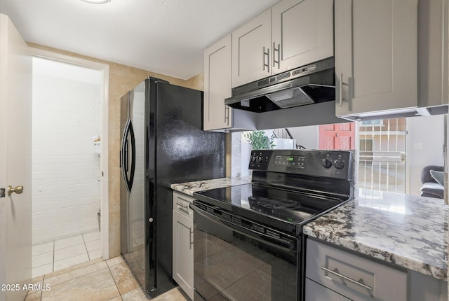 kitchen featuring gray cabinets, light stone counters, black electric range, and light tile patterned floors