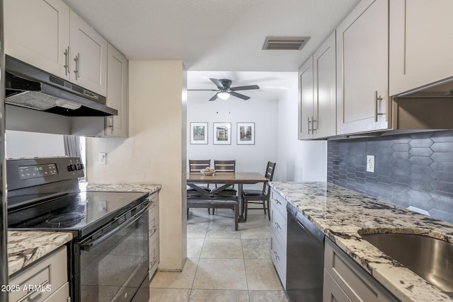 kitchen featuring dishwasher, light tile patterned floors, white cabinetry, and black / electric stove