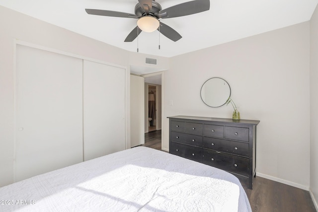 bedroom featuring dark hardwood / wood-style flooring, ceiling fan, and a closet